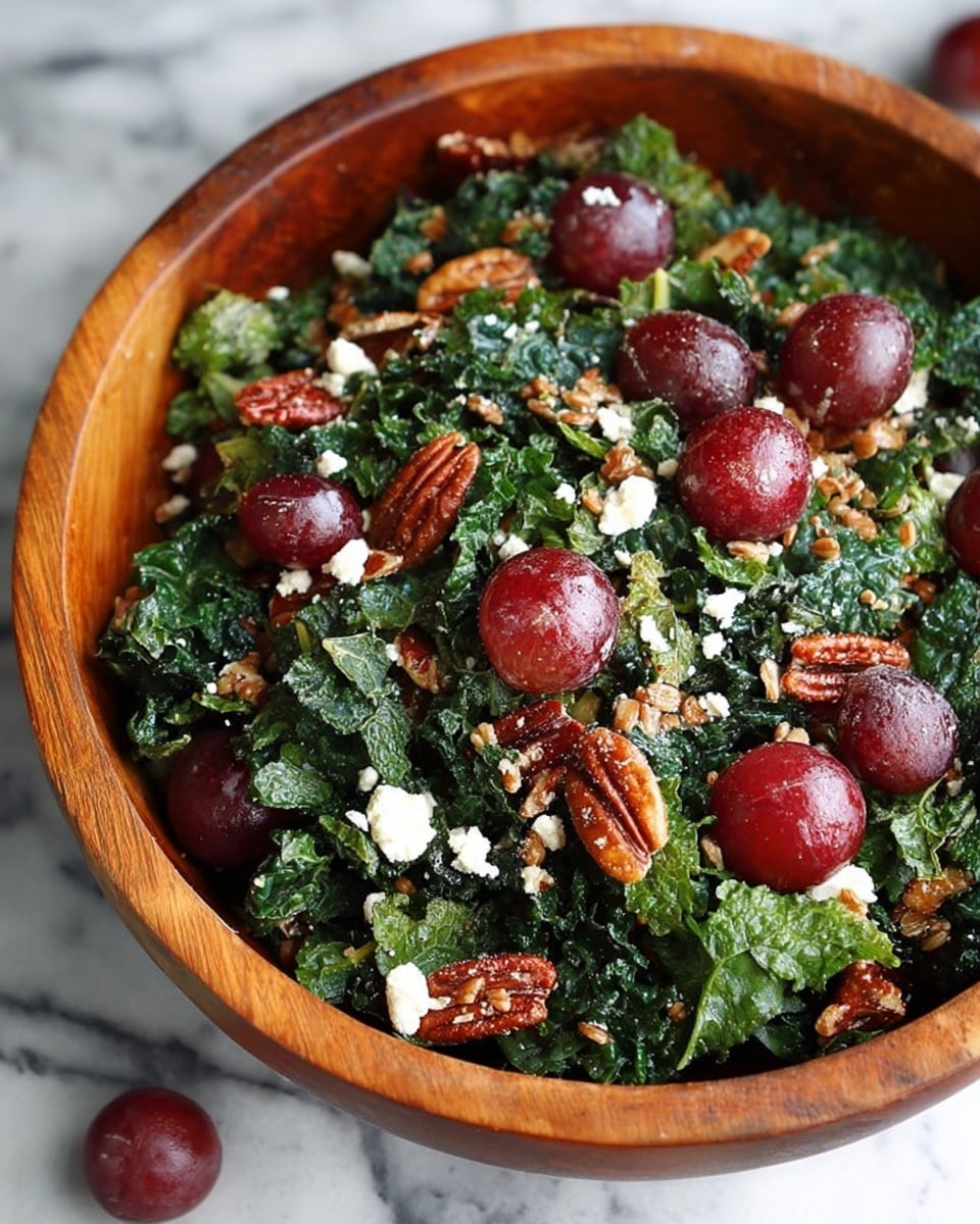 A wooden bowl filled with a fresh salad sits on a white marbled surface. The salad has dark green kale leaves as the base layer, giving a leafy textured look. Scattered throughout are bright red grapes, some whole and some sliced, adding smooth and shiny details. There are also crunchy brown pecan pieces spread evenly, creating contrasting rough textures. Small bits of crumbled white cheese sprinkle across the top, adding a soft and crumbly texture. Light brown grains are mixed in among the kale, grapes, pecans, and cheese, filling the spaces and adding another layer of texture. Photo taken with an iphone --ar 4:5 --v 7