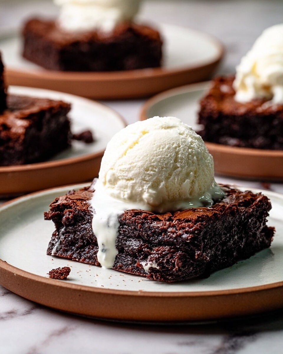 The image shows several square brownies with a rich, dark brown color and a shiny, cracked top layer that looks slightly crisp. Beneath the top is a moist and dense chocolate layer that appears thick and fudgy with melted chocolate spots visible in places. The brownies are laid out on a white marbled surface, closely packed together with slight gaps between them. The texture on the top layer has a delicate glossiness with small white flakes scattered over parts of the surface. photo taken with an iphone --ar 4:5 --v 7