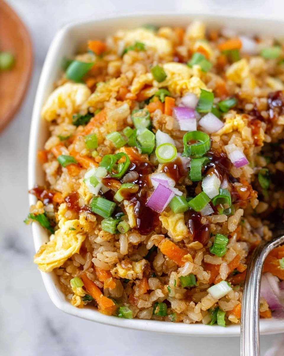 The image shows a dish of fried rice served in three small white bowls with handles, each filled with colorful layers including orange carrot shreds, light brown rice grains, and bits of yellow scrambled eggs, topped with chopped green onions and small pieces of red onion for garnish. Each bowl has a silver spoon inside, and behind them is a larger white dish filled with the same fried rice. The background surface is a white marbled texture scattered with small green herb pieces and broken brown eggshells, alongside a striped cloth in grey and white. The photo taken with an iphone --ar 4:5 --v 7