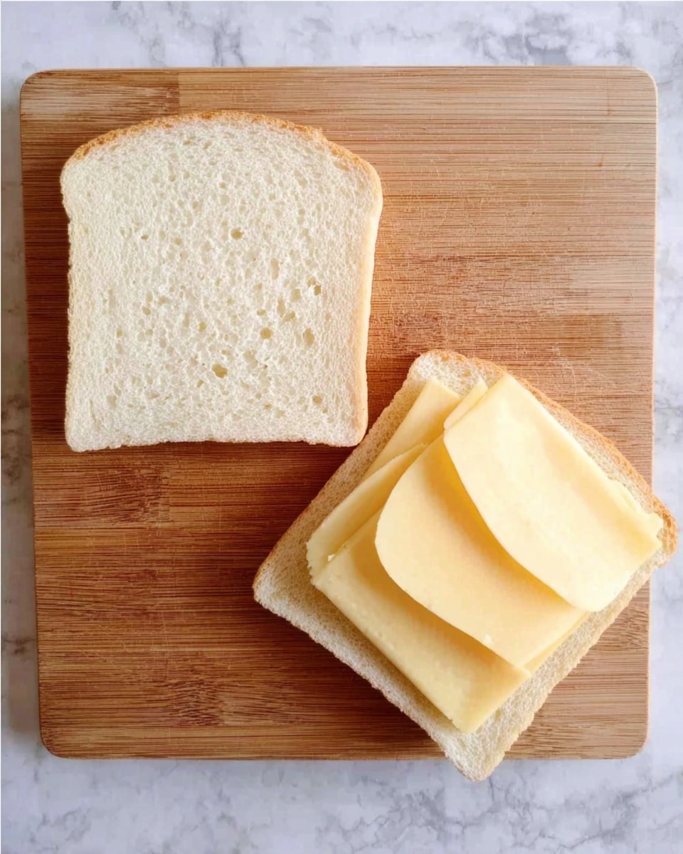 The image shows two toasted sandwich pieces on a wooden board, both with a golden brown crust. One sandwich is whole, square-shaped with a textured crust, while the other piece is triangular and lifted to reveal a thick layer of melted, stretchy white cheese between two slices of soft, toasted bread. The cheese has a smooth, creamy texture and stretches in long strings from the sandwich that is being lifted. The background is a white marbled surface with a red and white checkered cloth partially visible at the top. Photo taken with an iphone --ar 4:5 --v 7