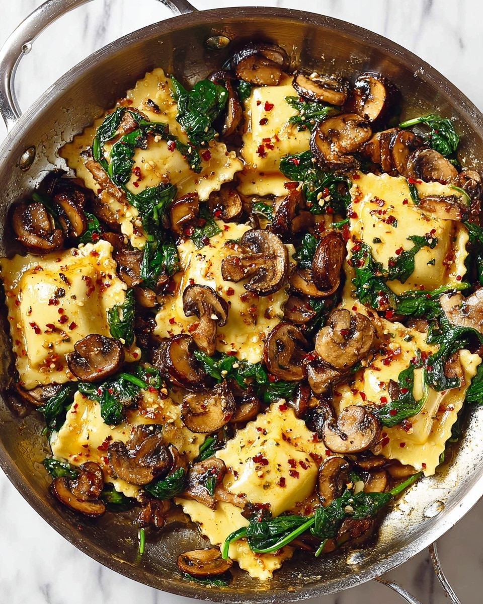 A pan filled with cooked ravioli pieces that are light golden-yellow with slightly crispy edges, mixed with dark brown cooked mushroom slices and bright green wilted spinach leaves, all sprinkled evenly with small red chili flakes, showing a glossy texture from the cooking oil. The ravioli are thick and square-shaped with crimped edges, nestled closely among the mushrooms and spinach, creating a colorful, textured, layered mix. The pan has a metallic finish, and the background is a white marbled surface. photo taken with an iphone --ar 4:5 --v 7