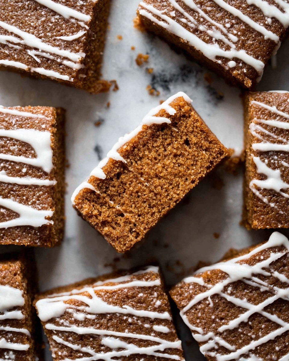 The image shows 25 small square pieces of brown cake arranged closely on a piece of parchment paper over a white marbled surface. Each cake piece has thin white icing drizzled unevenly on top, creating a contrast with the rich brown color of the cake. One piece is turned on its side revealing the soft texture of the inside, which is a consistent brown. Around the cakes are scattered crumbs and a few light beige almond slices. In the background, there is a cup of black coffee on the white marbled surface, a textured jar with a light beige lid, a white bowl with white icing or cream, a silver spoon, and a silver knife. The photo taken with an iphone --ar 4:5 --v 7