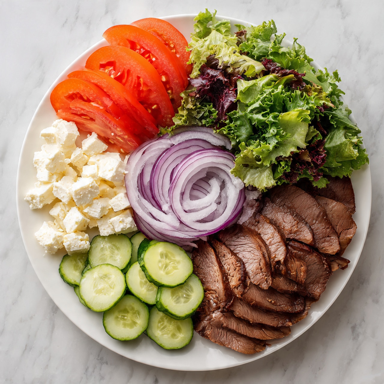 A large white plate on a white marbled surface holds six food sections arranged in a circle. The top right has dark and light green mixed leafy salad. Below it, several brown slices of cooked meat are layered closely together showing a slightly shiny texture. Moving counterclockwise, there are thin light purple ringed onion slices piled in the center. Below the onions, there are fresh green cucumber rounds stacked neatly. To their left, white crumbly cheese chunks are placed in a small pile. At the top left, bright red tomato wedges are arranged to show their juicy interiors. The overall look is fresh and colorful with each section clearly separate. photo taken with an iphone --ar 4:5 --v 7