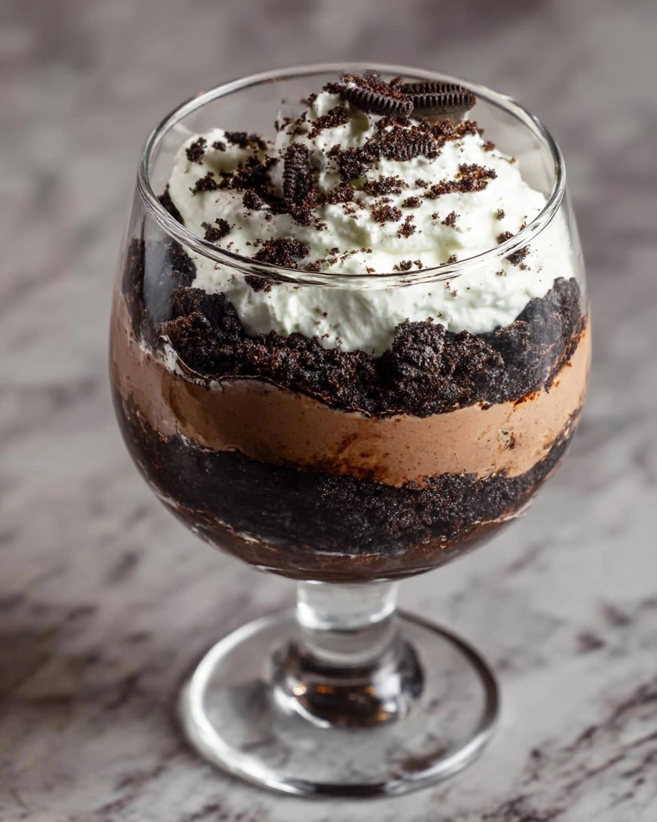 Four clear glass cups each show three main layers: at the bottom and middle are smooth, light brown creamy layers, separated by crumbly, dark brown cookie crumbs layers. The top layer is thick, white whipped cream sprinkled with more dark cookie crumbs and decorated with two dark brown coffee beans on each dessert. The cups sit on a dark wooden table, near three silver spoons placed on the left. Warm blurry string lights and a white marbled surface around add cozy light. photo taken with an iphone --ar 4:5 --v 7
