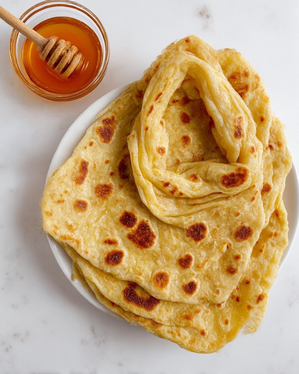 Five thin, square sheets of pale yellow dough are spread flat on a white marbled surface. Each sheet has soft, slightly uneven edges and a smooth but lightly textured surface, showing some thin creases and gentle folds. The dough appears soft and flexible, with a delicate sheen making it look fresh and lightly floured. The sheets are spaced apart, some overlapping slightly, giving a sense of preparation in progress. photo taken with an iphone --ar 4:5 --v 7