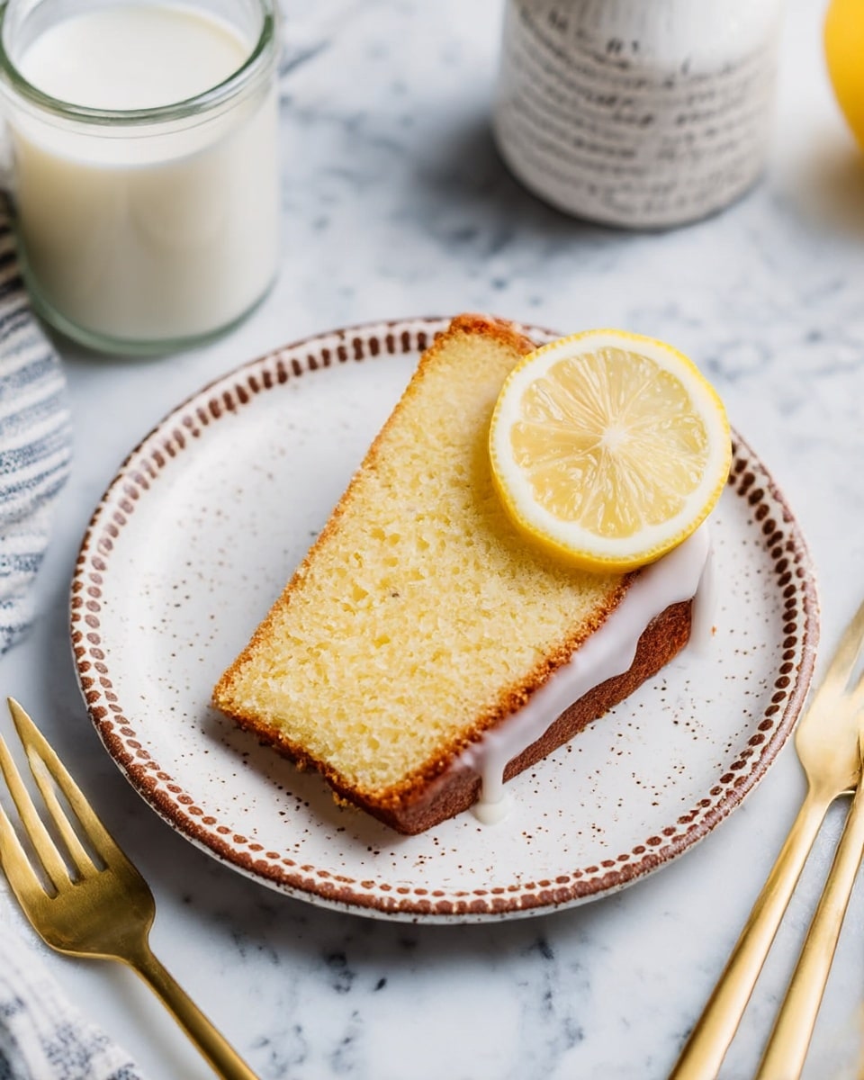 A bundt cake with a golden brown outer layer and a soft yellow inside is placed on a white plate. The top of the cake is covered with thick white icing that drips down the sides in uneven streams. Three thin lemon slices rest on the left side of the cake, and one lemon slice is placed on top near the middle. Two slices of the cake are cut and slightly pulled away, showing the moist texture inside with a light layer of icing on top. The white marbled surface underneath has scattered lemon halves and some gold forks on a decorative plate nearby, along with a glass of milk and a glass bottle. Photo taken with an iphone --ar 4:5 --v 7