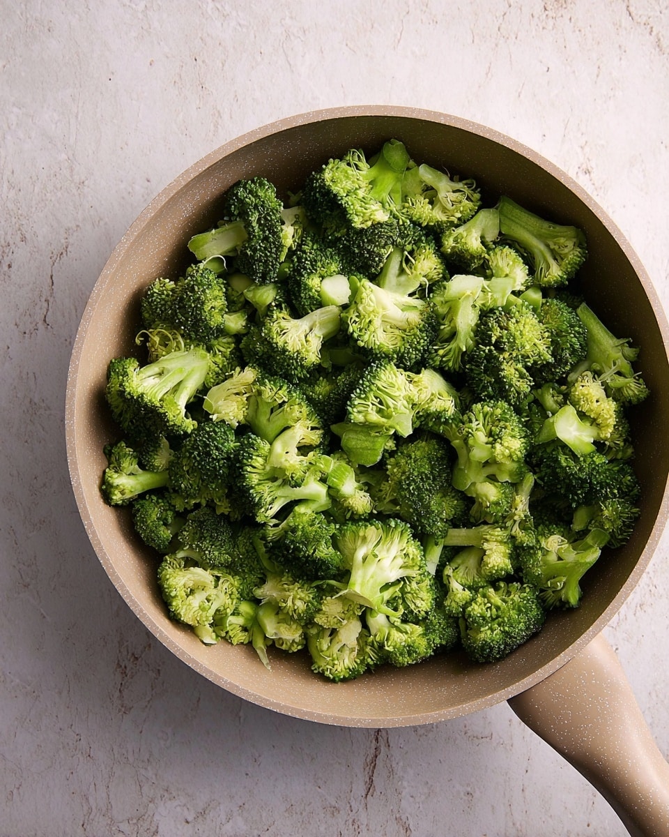 A white oval dish filled with a layered casserole. The bottom layer is small pieces of green broccoli mixed with a creamy white sauce. The top layer is a thick, even covering of crushed golden crackers with bits of herbs mixed in. The dish is placed on a white marbled textured surface. photo taken with an iphone --ar 4:5 --v 7
