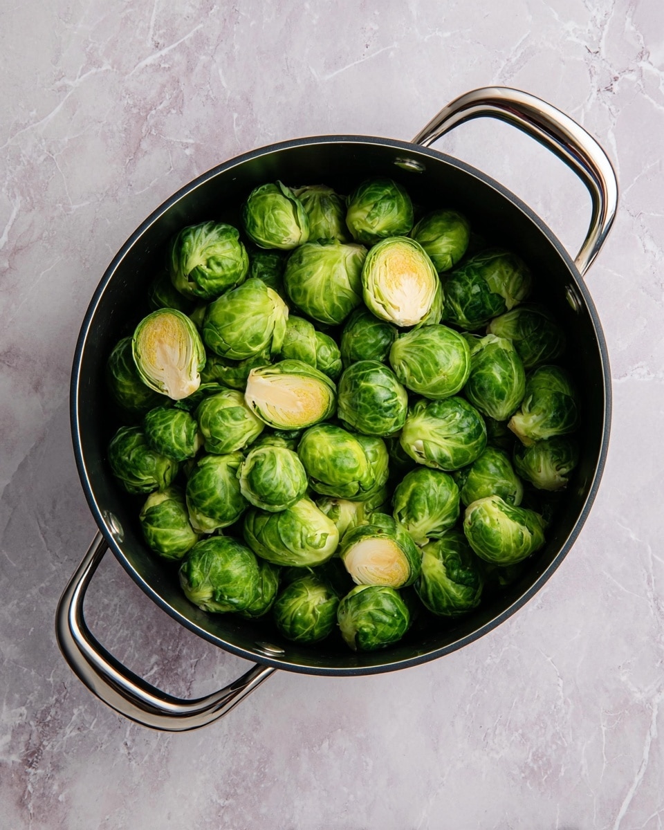 A black pot filled with fresh green Brussels sprouts, some whole and some cut in halves showing pale green and cream inner layers, placed on a white marbled surface. The pot has two shiny metal handles, one on each side, and the Brussels sprouts are tightly packed, covering the entire pot interior. Photo taken with an iphone --ar 4:5 --v 7