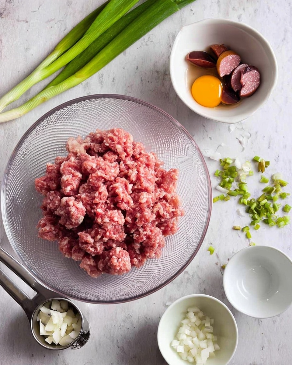 A clear textured glass plate sits on a white marbled surface, filled with a mound of pink raw ground meat, rough and chunky in texture. Above and to the right, there is a small white bowl holding pieces of preserved egg with dark brown yolks and deep red sausage slices, showing smooth and glossy surfaces. Towards the top of the image, a small white bowl decorated with green onions and light green stalks rests, alongside scattered whole green onions putting a fresh bright green contrast. At the bottom left, there is a silver metal measuring cup filled with small white chopped bits, slightly translucent. Next to these bowls, an empty white bowl is placed. The light is soft and even, bringing out the natural colors and textures of each ingredient photo taken with an iphone --ar 4:5 --v 7