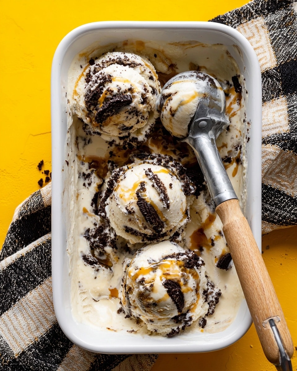 A white rectangular dish filled with a creamy, swirled dessert that has a smooth, light beige base mixed with caramel-colored streaks flowing through it. Scattered on top are about eight pieces of dark chocolate sandwich cookies, some whole halves and some broken, creating contrast with the pale dessert color. The dish is held by two hands with bright green and white nail polish and small tattoos visible on the wrist and fingers. The background is a bright yellow textured surface. photo taken with an iphone --ar 4:5 --v 7