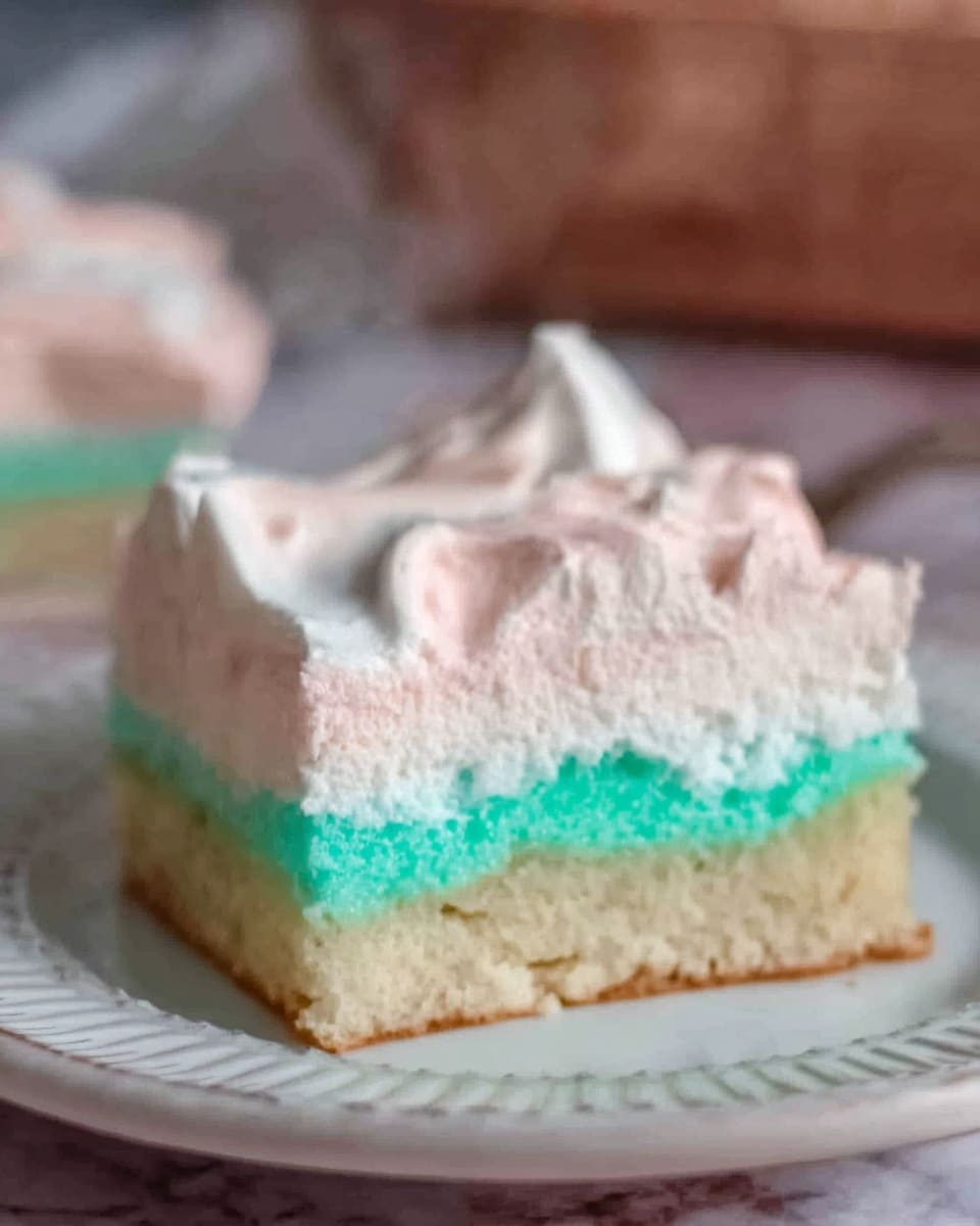 The image shows a square piece of cake on a white plate with a textured rim, placed on a white marbled surface. The cake has three layers: the bottom layer is light beige with a soft, spongy texture; the middle layer is thin and bright turquoise, slightly uneven with a smooth texture; the top layer is thick and creamy light pink, fluffy and swirled on top. The background is blurred with some neutral and brown tones. Photo taken with an iphone --ar 4:5 --v 7