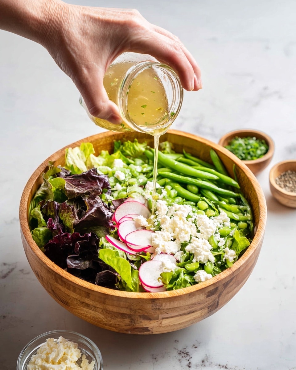 A wooden bowl filled with a fresh mixed salad that has three main layers: a base of bright green leafy lettuce, a middle layer of dark purple leafy greens, and thinly sliced white radishes with pink edges scattered on top. White crumbles of soft cheese are spread evenly over the salad, with small green chives sprinkled all over, adding fine texture. The bowl rests on a blue striped cloth, all placed on a white marbled surface. The photo taken with an iphone --ar 4:5 --v 7