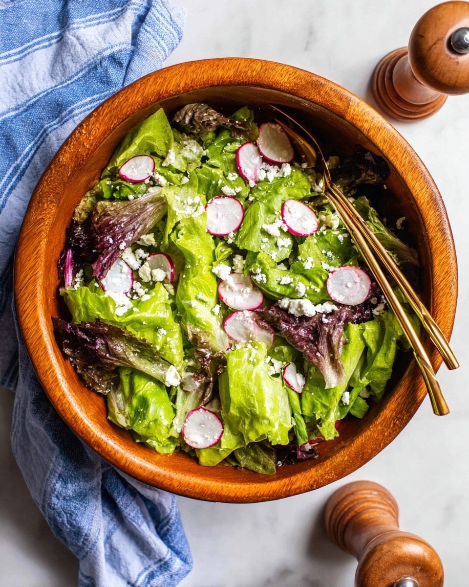 A large wooden bowl filled with fresh salad showing multiple layers: the bottom layer has green and purple leafy lettuce with crisp texture, topped with thinly sliced round radish pieces that have bright red edges and white centers, scattered with small white soft cheese crumbles throughout. Two thin golden chopsticks rest inside the bowl, and the bowl is placed on a white marbled surface next to wooden salt and pepper shakers and a blue-striped cloth. Photo taken with an iphone --ar 4:5 --v 7