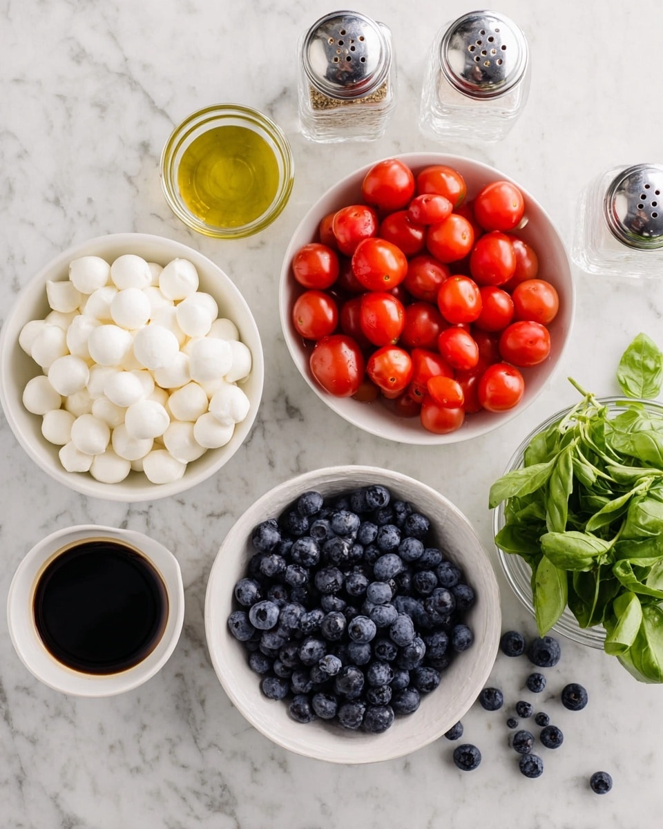 The image shows a top view of several small white bowls on a white marbled surface. One bowl is filled with bright red cherry tomatoes, another with white small mozzarella balls, and a third with dark blue blueberries. Next to the bowls, there is a small white cup with dark balsamic vinegar and another small white cup with light olive oil. There is also a small white bowl filled with bright green fresh basil leaves, and two clear glass shakers with salt and pepper. A few blueberries are scattered on the surface around the bowls. Photo taken with an iphone --ar 4:5 --v 7