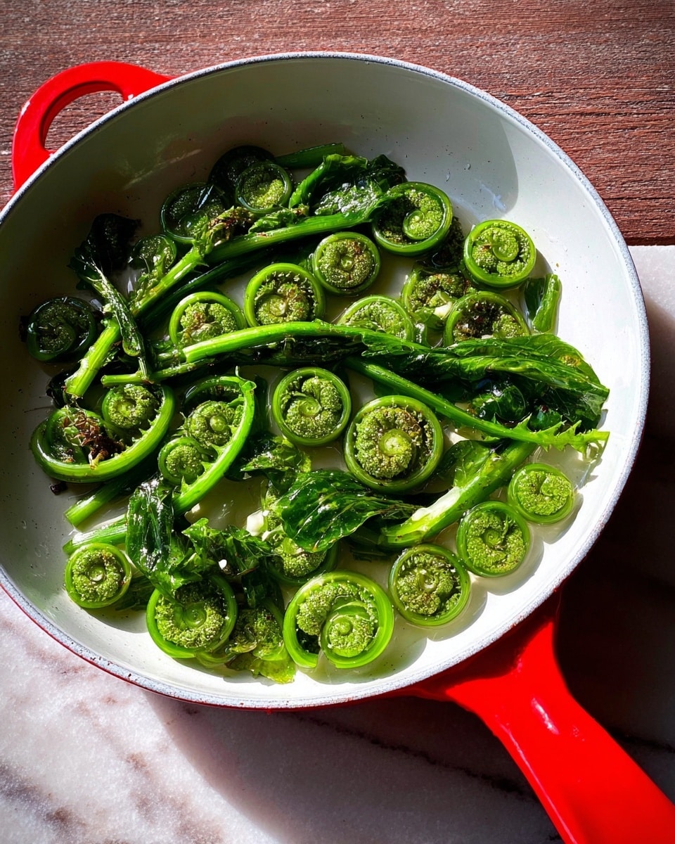 A close-up top view of a bright yellow scalloped ceramic bowl filled with fresh, tightly curled green fiddlehead ferns. The ferns show various spiral shapes and textures, with the inner parts having small, delicate leafy details in a slightly lighter green. The bowl sits on a white marbled surface with a glimpse of a white cloth and some additional fiddleheads nearby. The colors are vibrant, with the green of the ferns contrasting against the yellow bowl and the white marbled background. photo taken with an iphone --ar 4:5 --v 7