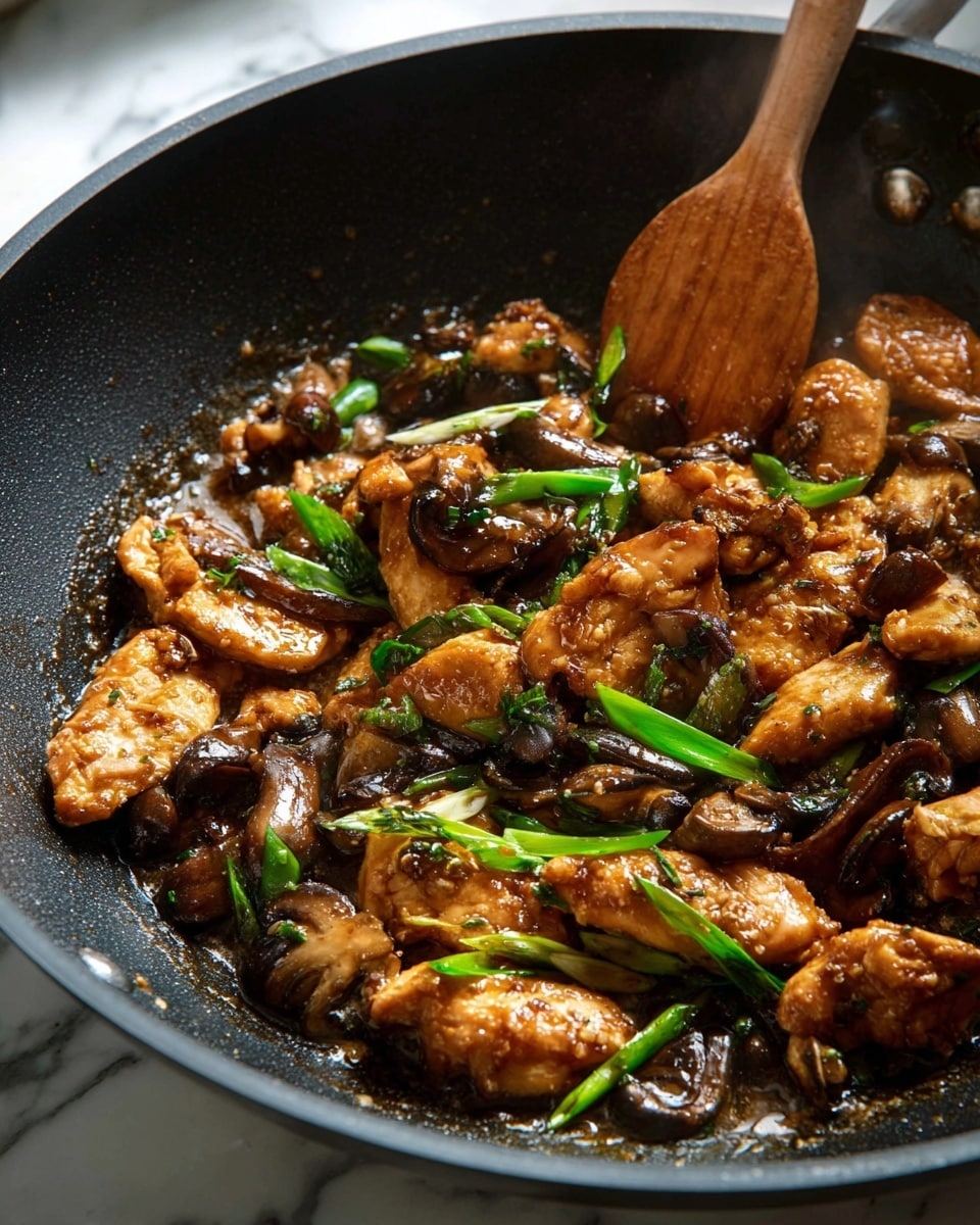 A large black wok filled with cooked small brown pieces of chicken mixed with sliced brown mushrooms and dark mushrooms, all coated in a shiny brown sauce, with chopped green onions scattered throughout. A wooden spatula rests inside the wok, scooping up some of the chicken and mushrooms. The wok sits on a white marbled surface, with a white measuring cup holding whole mushrooms to the top left, a wooden pepper grinder and fresh green onions on a wooden board to the top right, and a white dish with chopped green onions to the bottom right. Some mushroom pieces and green onion slices are scattered around on the surface. A white cloth with a blue checked pattern is placed near the wok's handle. photo taken with an iphone --ar 4:5 --v 7