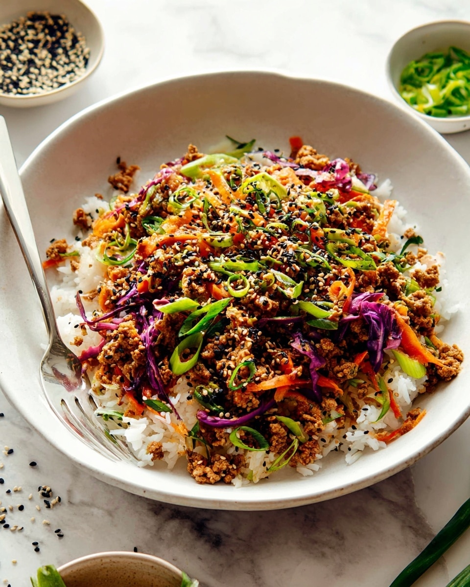 A white bowl is filled with a base layer of white rice, topped with a colorful stir-fry made of cooked light brown ground meat mixed with thin strips of orange carrots and purple cabbage. Green slices of scallions are scattered on top along with black sesame seeds, creating a variety of green and black specks. There is a silver fork resting on the left side of the bowl on the white marbled surface, and small bowls with more seeds and green vegetables are partly visible at the top right. The overall look is fresh and vibrant with many small, textured details. photo taken with an iphone --ar 4:5 --v 7
