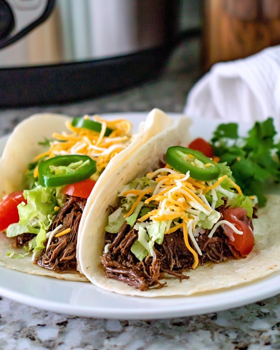 Two soft white corn tortillas are folded side by side on a white plate, each filled with shredded dark brown beef as the bottom layer. On top of the beef, there is a layer of chopped light green lettuce and scattered pieces of red tomato. Thin, mixed shredded cheese in white and pale orange is sprinkled over the filling. Thin slices of green jalapeño peppers sit near the top along with fresh green cilantro leaves. The plate is set on a white marbled surface with a slightly blurred kitchen background. photo taken with an iphone --ar 4:5 --v 7