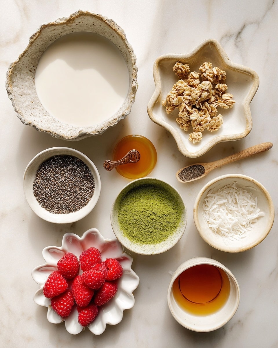 The image shows several small white ceramic bowls and a plate on a white marbled surface, each filled with different ingredients. In the top left, a large rough-edged bowl is filled with a creamy white liquid. To its right, a star-shaped bowl holds light brown clusters of granola, with some scattered on the surface. Below the granola, a small bowl contains bright green matcha powder with a fine texture. To the left, a smaller bowl holds a clear amber liquid, possibly syrup. Below and to the center left is a small bowl filled with black chia seeds and a small wooden scoop on top. To the right, a bowl contains fine white shredded coconut. At the bottom left, a white scalloped plate holds several fresh, plump red raspberries. Near the bottom right, there is another small bowl with a similar amber liquid. The scene is bright and clean with natural lighting, photo taken with an iphone --ar 4:5 --v 7